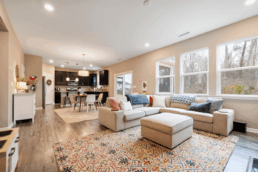 Living with a sectional couch, ottoman, and kitchen in the background