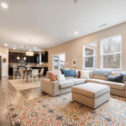 Living with a sectional couch, ottoman, and kitchen in the background